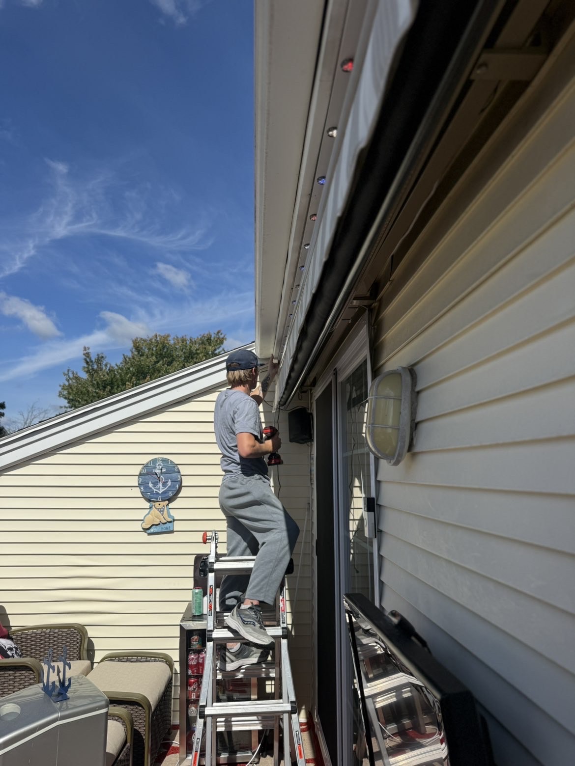 NE Lighting Solutions installer fitting compact lighting along a home’s soffit